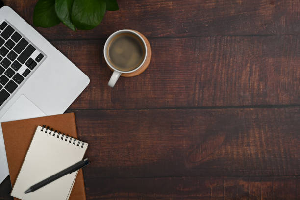 istock Top view laptop computer, notepad, coffee cup and succulent plant on office desk. 1415124374