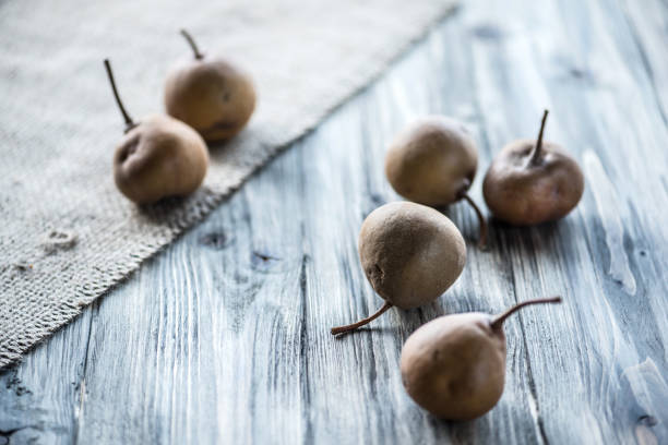 Small Brown Ripe Pears on Rustic Wooden Table