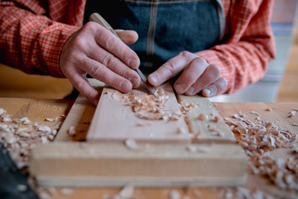 istock Carpenter working in his workshop, he is smoothing a wooden board using a planer, carpentry, carpentry, woodworking and craftsmanship concept 1415130772