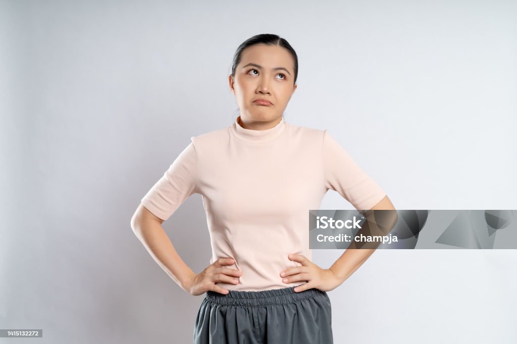 Asian woman shrugs her arms and makes gesturing of she don't know isolated over white background. Asian woman shrugs her arms and makes gesturing of she don't know standing isolated over white background. Women Stock Photo
