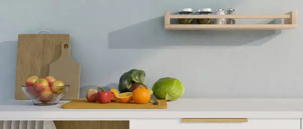 Photo of Modern white kitchen countertop with fruits and vegetables on wooden chopping board and copy space