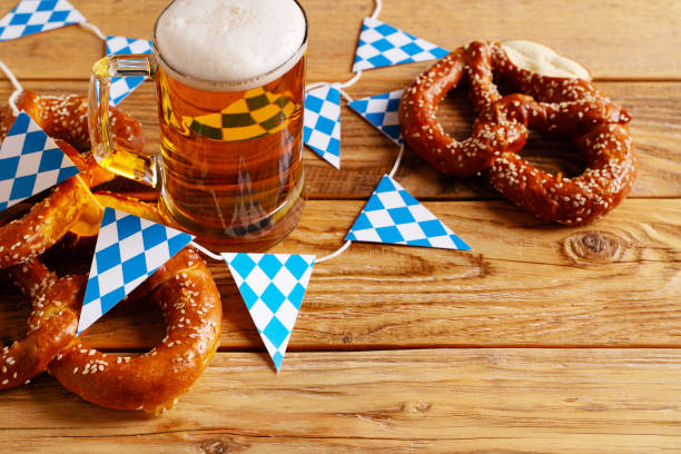 Beer Fest concept with pretzel and blue simbol flag on wood background Beer Fest concept with pretzel, mug of beer and blue simbol flag on wood background, copy space, top view, flat lay, vertical beer festival photos stock pictures, royalty-free photos & images