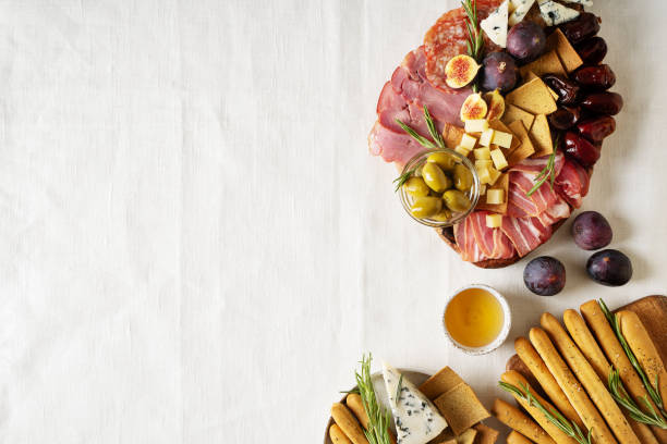 istock Meat, cheese and snackes plate, board and grissini on white background 1415134374