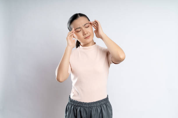 istock Asian woman was sick with headache standing isolated on white background. 1415134459