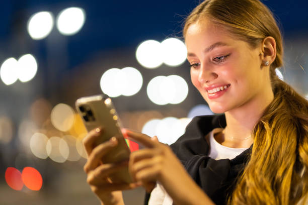istock Woman use smartphone on background bokeh light in night city 1415134608