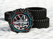 Group of winter tires with snow chains standing on snowy surface