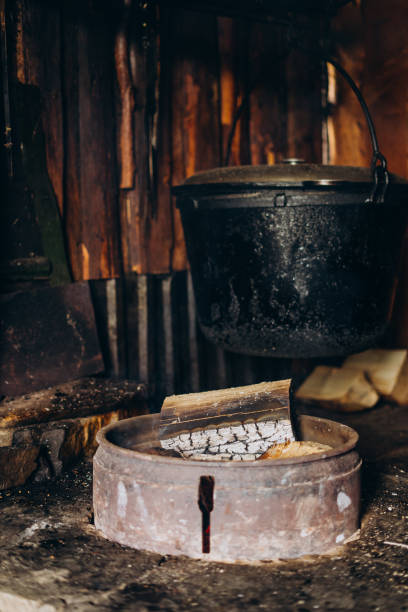 istock A large vat in which cheese is cooked over an open fire. The cauldron is prepared over an open wood fire. Cheese factory in the mountains. 1415136249
