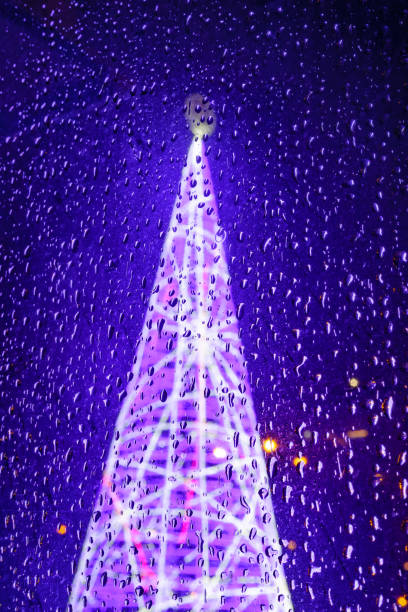 aufnahme von regentropfen auf glas gegen weihnachtsbaum im hintergrund. regen zu weihnachten - fog wet rain tree stock-fotos und bilder