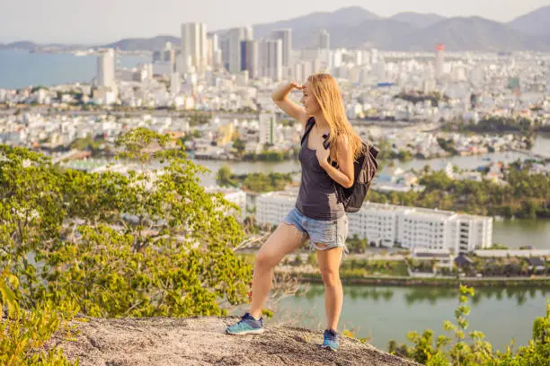 Photo of Woman tourist on the background of Nha Trang city. Travel to Vietnam Concept