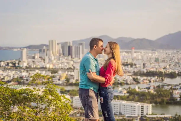 Photo of Happy couple tourists on the background of Nha Trang city. Travel to Vietnam Concept