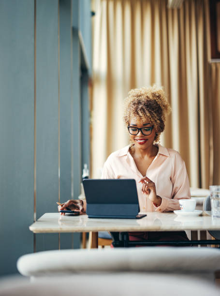 istock Smiling Businesswoman Using Digital Tablet In The Cafe 1415141942