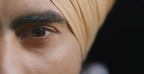 Close-up of young man with brown eye looking at camera.