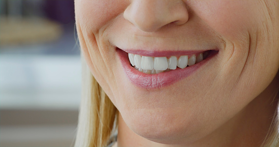 Close-up of smiling senior woman with pink lips.