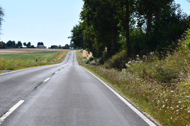 istock straight country road up the wave shaped hills 1415145737