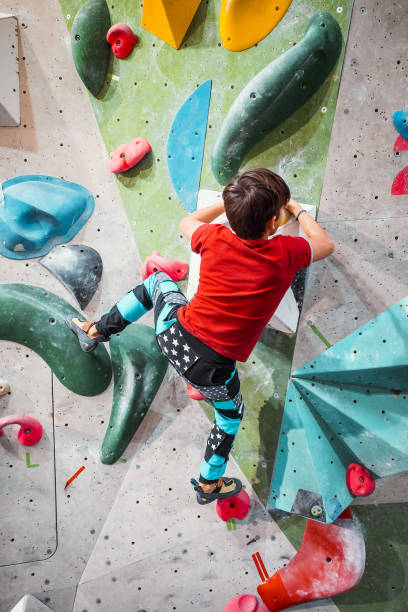 istock Young boy climbing an indoor climbing wall 1415146827