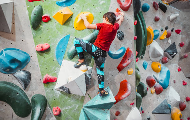 Young boy climbing an indoor climbing wall
