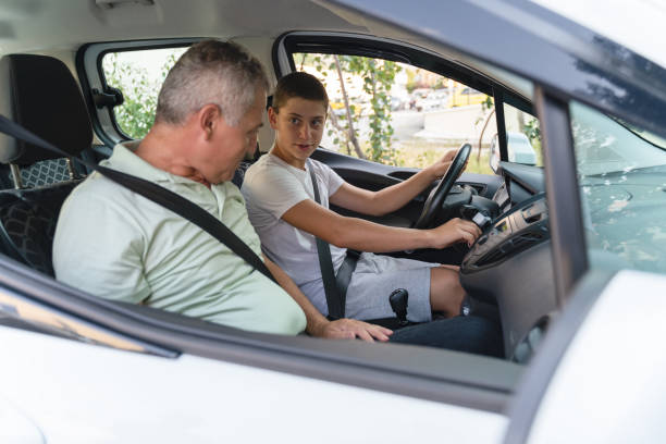istock Young man learning how to drive car together with his father 1415148486