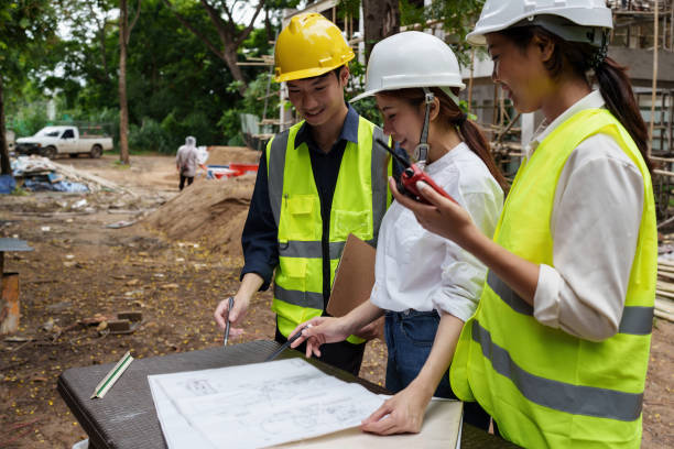 istock Structural engineer and architect discussing and working with blueprints at the outdoors construction site 1415148521