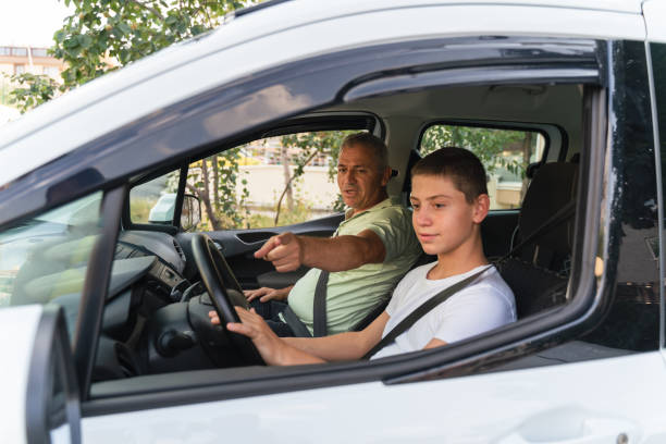 giovane che impara a guidare l'auto insieme a suo padre - driving test foto e immagini stock