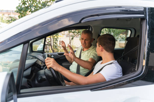 istock Young man learning how to drive car together with his father 1415148650