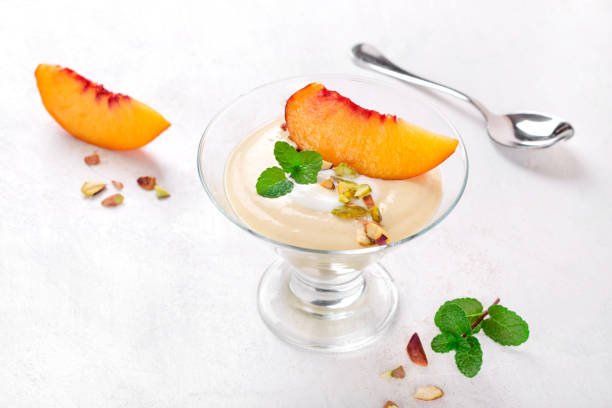 joghurt-dessert mit nektarinenscheibe - peach nectarine fruit portion stock-fotos und bilder