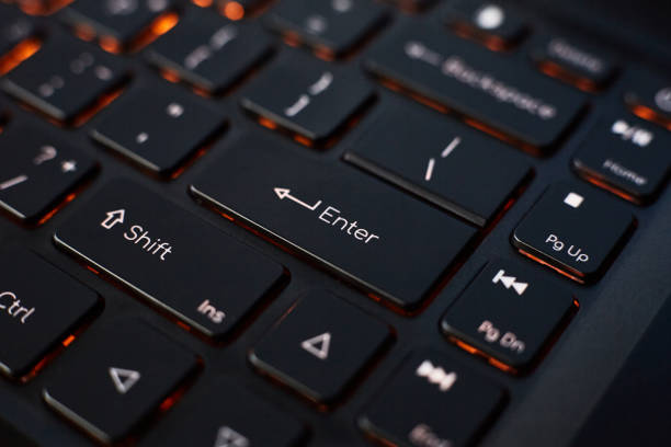 istock Close-up of a laptop keyboard with orange backlight. 1415151240