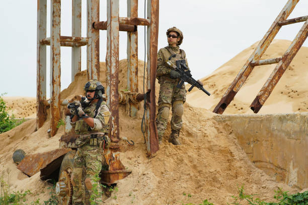 istock soldier in the battle field claim up to steel structure for security check while team hold the gun alert look around 1415151935