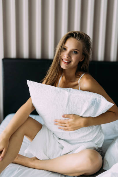 istock Young woman hugging pillow on comfortable bed 1415153207