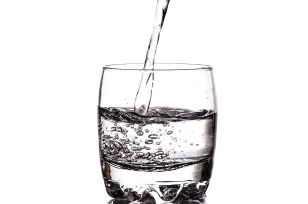 Pouring fresh water in a glass isolated on white background stock photo