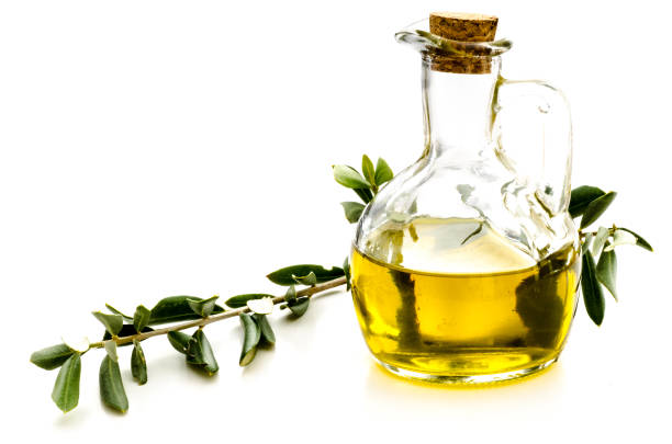 Olive oil in a bottle with a twig from an olive tree isolated on white background stock photo