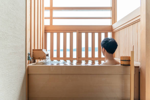 hombre asiático tomando un baño al aire libre en la habitación de invitados - baños térmicos fotografías e imágenes de stock