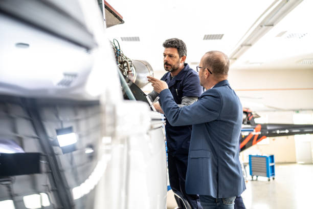 istock Helicopter hangar worker chatting with private jet owner 1415157525