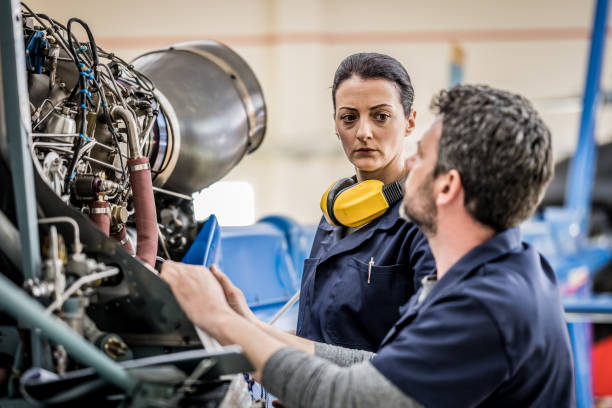 istock Airplane engineer examining helicopter engine and supervising trainee 1415157533
