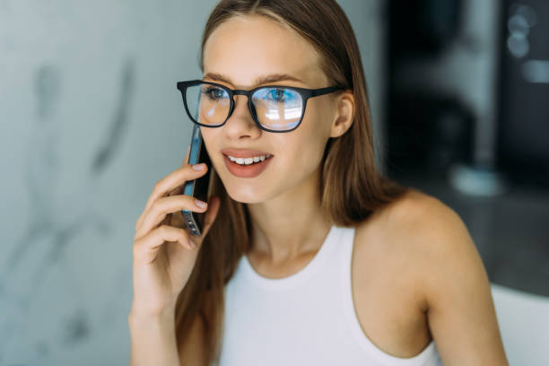 istock Freelance woman working from home, sitting at kitchen table, using laptop and having phone conversation, looking at computer screen. Remote job concept 1415158019