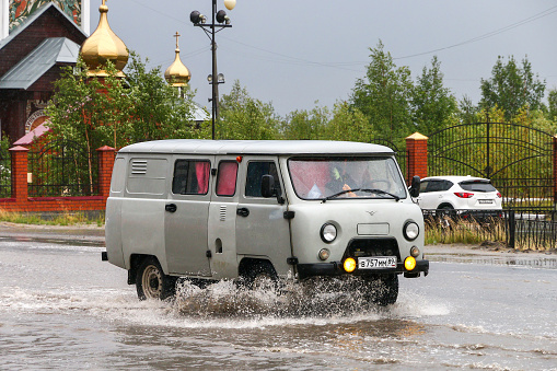 Novyy Urengoy, Russia - August 14, 2018: Compact offroad truck UAZ-3909 in the city street during a flood.