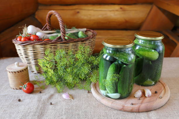 istock Glass jars of pickles next to fresh vegetables. 1415160790
