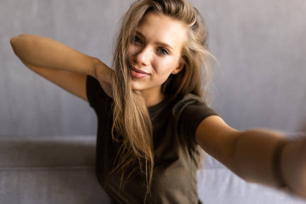 istock Young amazing woman make selfie on sofa indoors. 1415161482