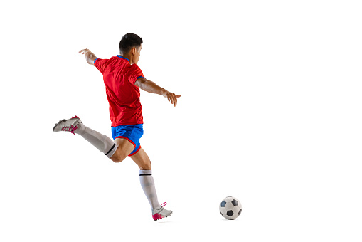 Dynamic portrait of young man, professional football player in motion, training, dribbling ball isolated over white studio background. Concept of sport, team game, action, motion. Copy space for ad