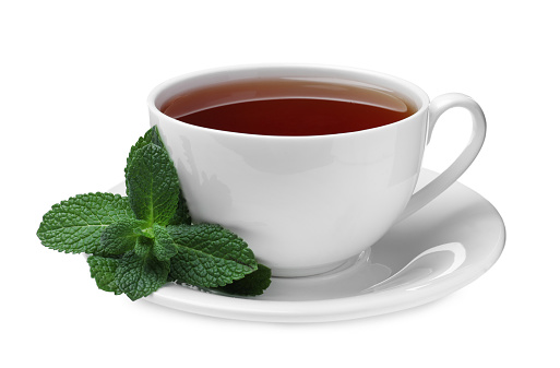 Cup of aromatic black tea with fresh mint on white background