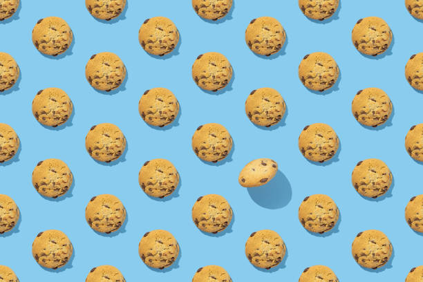 istock Pattern of sweet chocolate cookies on blue background with hard shadows. Flat lay, high quality photo 1415163676