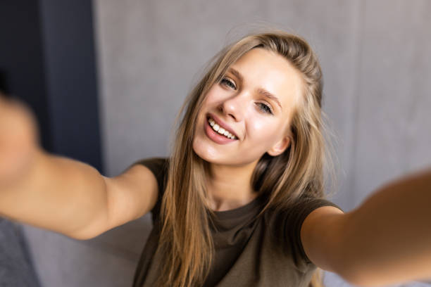 istock Young amazing woman make selfie on sofa indoors. 1415163737
