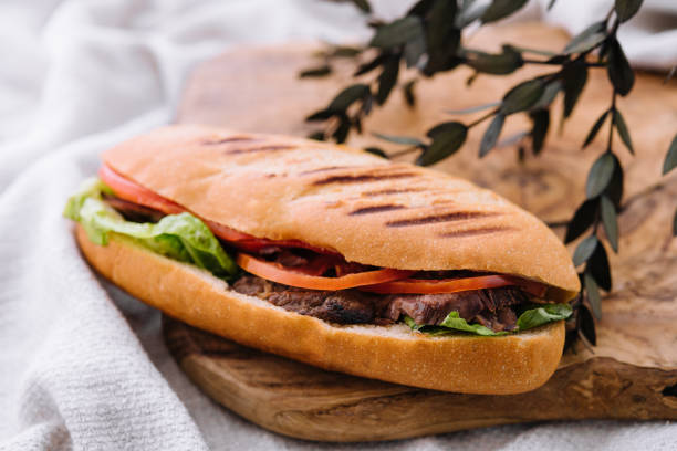 istock Sandwich with meat and vegetables on a wooden board 1415164049