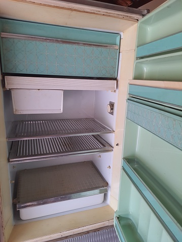 Old refrigerator, retro insulated, with the door open.