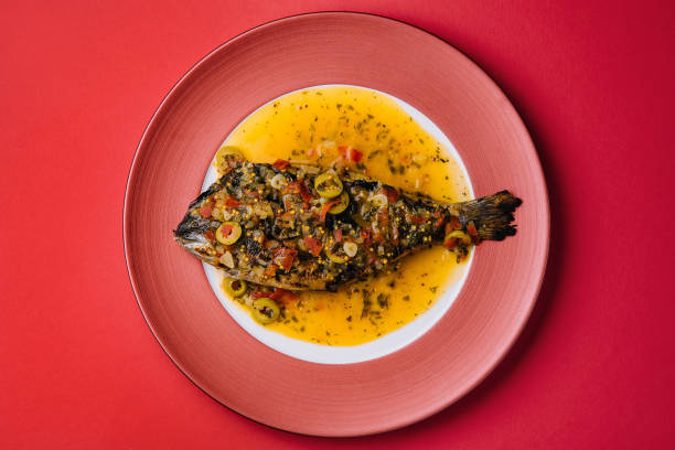istock Dorado baked with special sauce on red plate 1415164181
