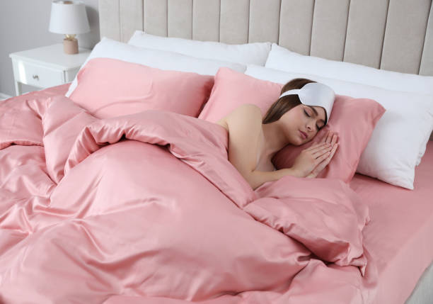 istock Young woman sleeping in comfortable bed with silky linens 1415166779