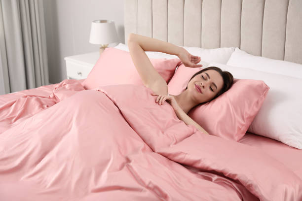 istock Young woman awaking in comfortable bed with silky linens 1415166943