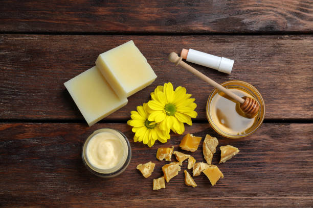 istock Flat lay composition with beeswax and cosmetic products on wooden table 1415167204