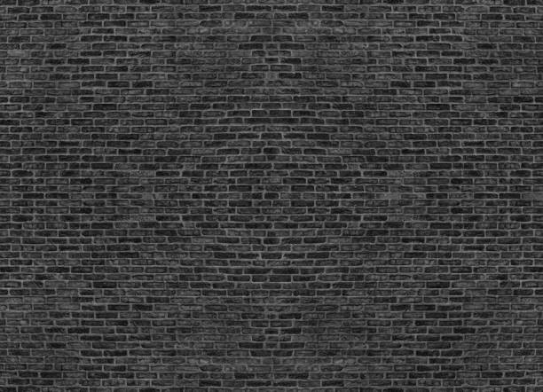 Large old black brick wall distressed texture. Rough brickwork grunge dark background