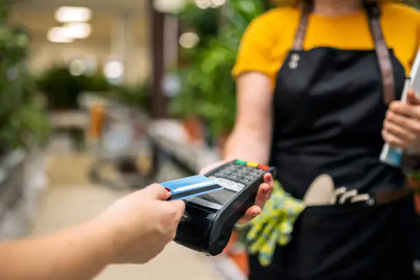 Greenhouse workers selling pottered flowers ,credit card purchase