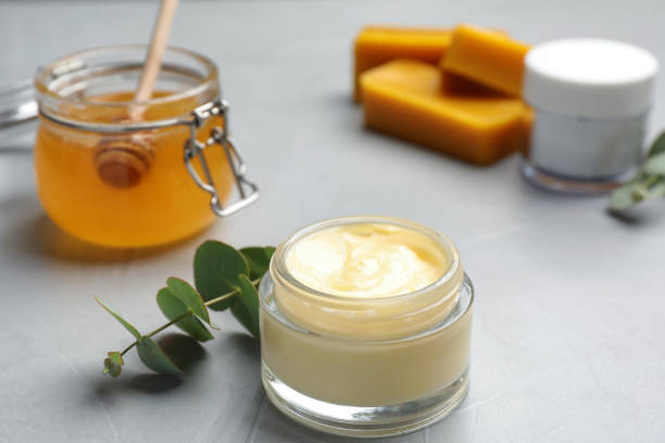 istock Cream with natural beeswax component on light grey stone table 1415168392